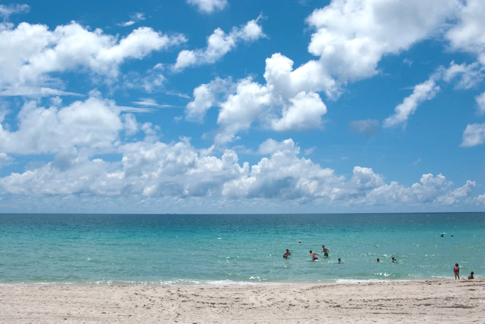 Turquoise water and a sandy beach beneath clouds on Koh Samui